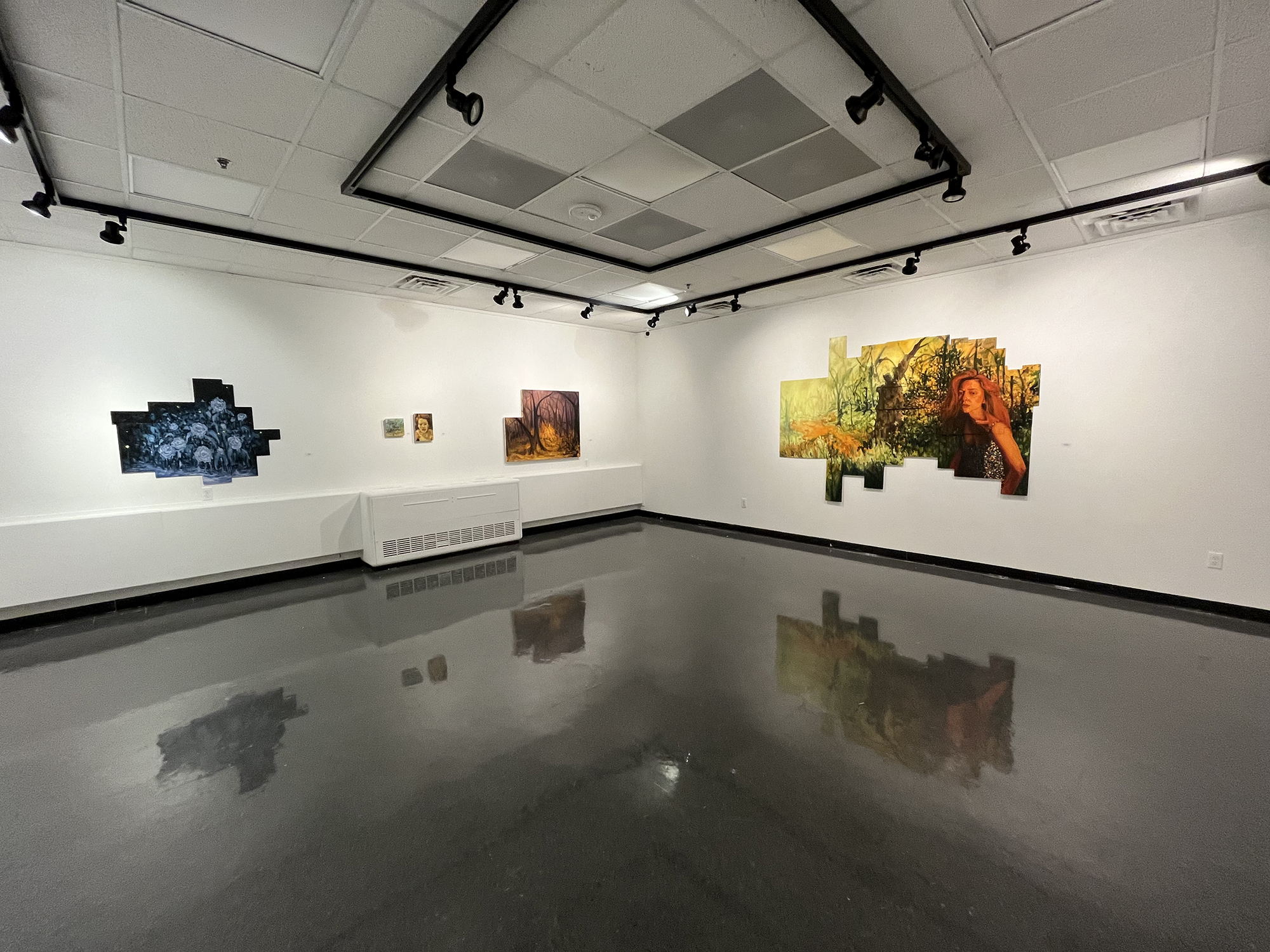 gallery with grey floor and white walls, orange painting on the right, blue and red paintings on the left